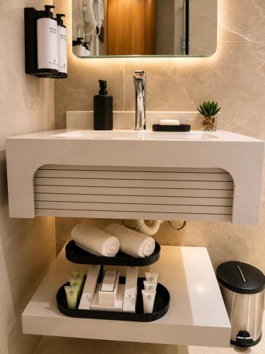 a bathroom with a sink and a white counter with towels at Golden Tulip Al Shakreen in Medina