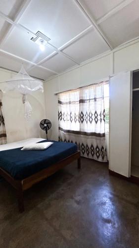 a bedroom with a bed and a window with curtains at Crystal Hostels in Livingstone