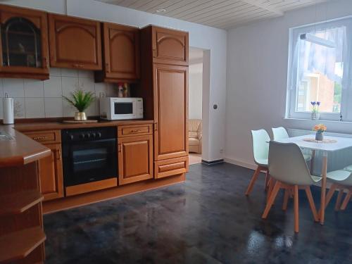 a kitchen with wooden cabinets and a table with chairs at Horstis Fewo Apartment Reni in Frankenhain