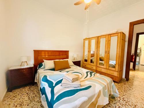 a bedroom with a large bed with a wooden headboard at Cala de Los Lobos in Puerto de Mazarrón