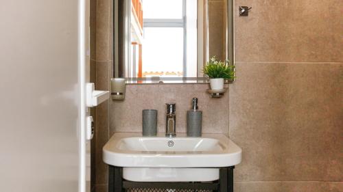 a bathroom with a white sink and a mirror at Mini Stylish - Central Studio w kitchen in Himare