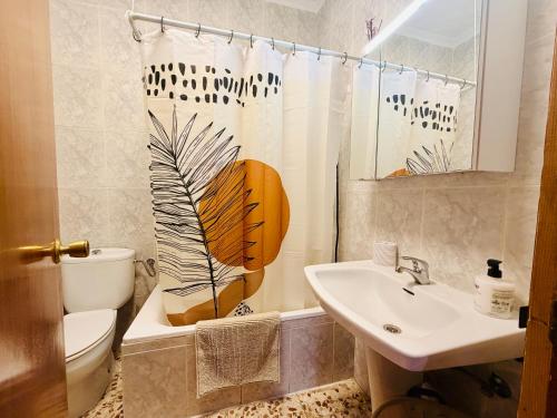 a bathroom with a sink and a toilet and a shower curtain at Cala de Los Lobos in Puerto de Mazarrón