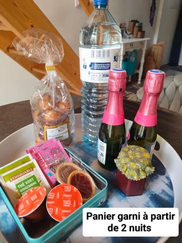 a table with two bottles of wine and a tray of food at La Suite 27 bis, maison de charme avec terrasse, proche gare et centre in Guingamp