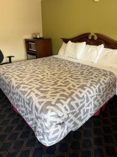 a bed in a hotel room with a comforter at Bing's Motel in Williamsport