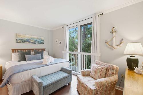 a bedroom with a bed and a chair and a window at 2479 Shipwatch in Kiawah Island