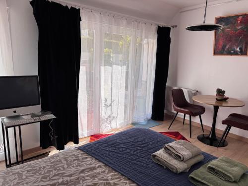 a bedroom with a bed and a television and a table at Villa Auguste chambres d'hôtes in Quimper