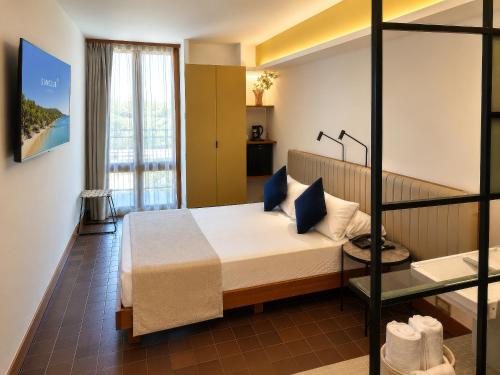 a bedroom with a bed with blue pillows at Hotel SunClub CalaVinya in Salou