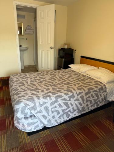 a bedroom with a bed and a bathroom at Bing's Motel in Williamsport