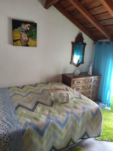 a bedroom with a bed and a dresser and a mirror at Casa da Cristina in Nazaré
