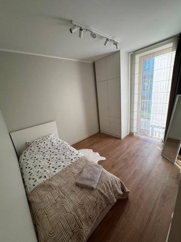 a bedroom with a bed and a large window at Cozy corner89, private parking in Valmiera