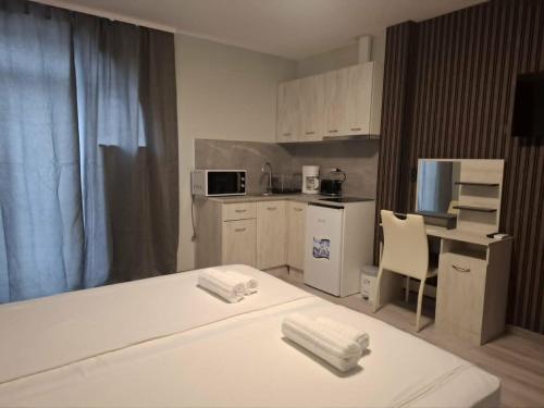 a room with a kitchen with a bed and a table at Gardenia Guest House in Balchik