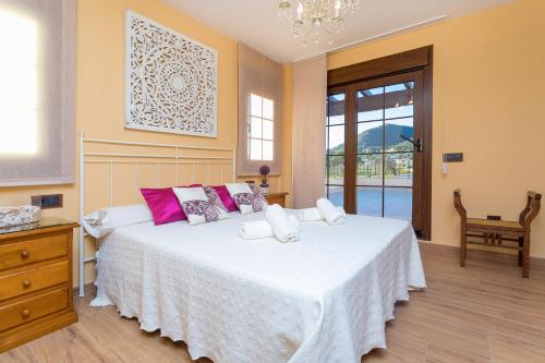 1 dormitorio con 1 cama blanca grande con almohadas rosas en Villa Campo Sol en Ibiza
