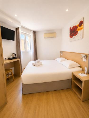 a hotel room with a bed and a television at Holzer II in Porto-Vecchio