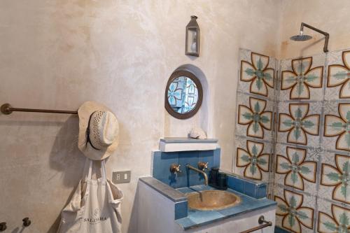a bathroom with a blue sink and a window at Villa Salinara in Marsala
