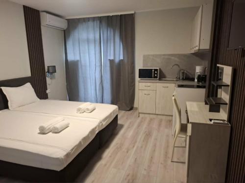a hotel room with a bed and a kitchen at Gardenia Guest House in Balchik