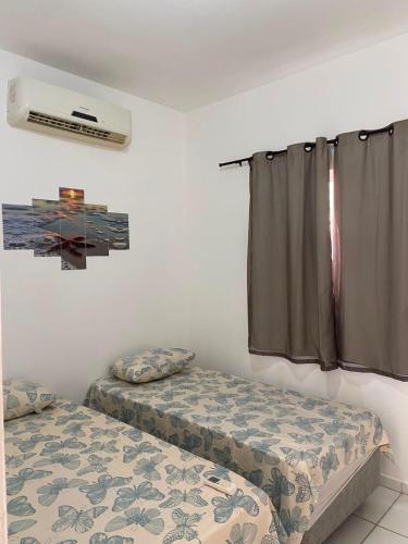 a room with two twin beds and a window at Refúgio da Praia in Caucaia