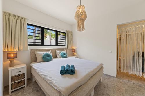 a bedroom with a bed with blue shoes on it at Luxe Tropische Villa met Privézwembad in Jan Thiel