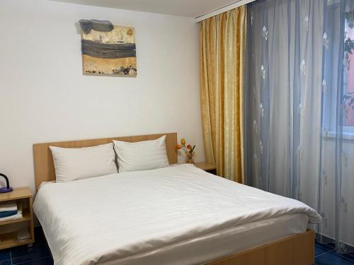 a bedroom with a white bed and a window at Casa Double M, Vama Veche in Vama Veche