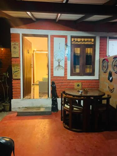 a room with a table in front of a brick wall at Angry birds rooms in Habarana