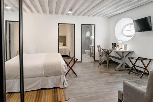 a bedroom with a bed and a table in a room at Hotel La Morada in San Miguel de Allende