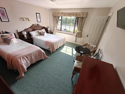 a hotel room with two beds and a window at Riverview House in Athlone