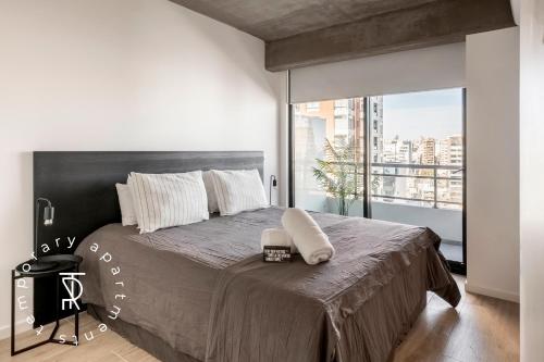 a bedroom with a large bed with a large window at Top Rentals Nuñez in Buenos Aires