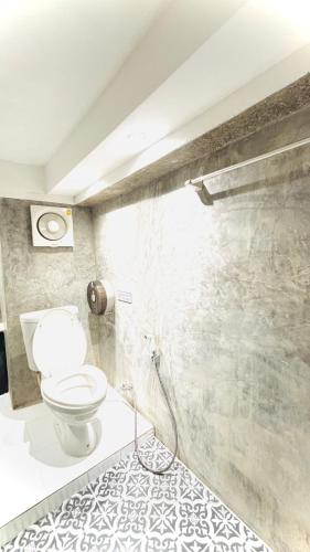 a bathroom with a white toilet in a room at The Yak Cozy Chiang Mai in Chiang Mai