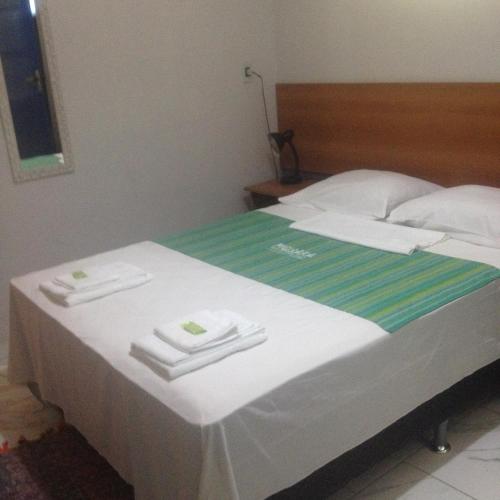 a bed with towels on top of it at Pousada Piquara in Mangaratiba