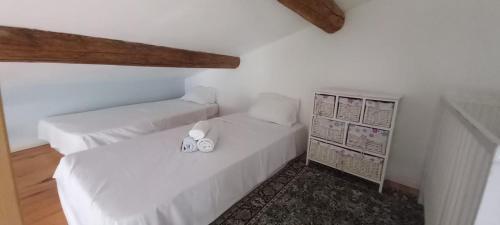 two beds in a room with white walls and wooden floors at OCC34 - Capestang - Vigneron in Capestang
