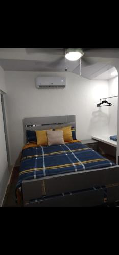 a bedroom with a bed with blue and yellow pillows at 4 Bedroom 4 Bath & Laundry Room Apartment in Sosúa