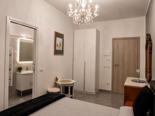 a bedroom with a bed and a bathroom with a chandelier at B&B Jasmine Park Ormea in Ormea