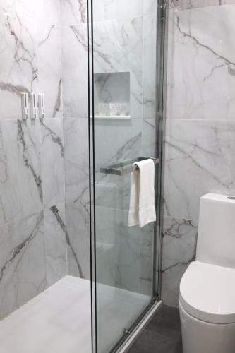 a bathroom with a glass shower with a toilet at Travelodge by Wyndham Quebec City Hotel & Convention Centre in Quebec City