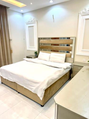 a bedroom with a large bed with white sheets at شاليهات حياة روز in Taif