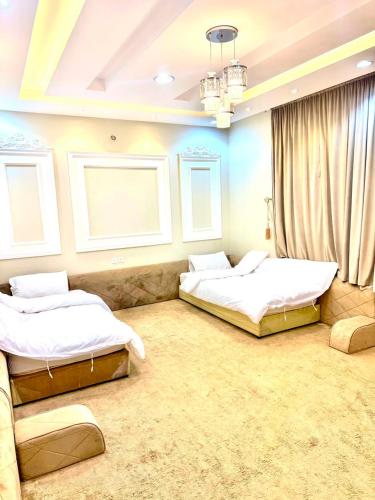 two beds in a room with two windows at شاليهات حياة روز in Taif