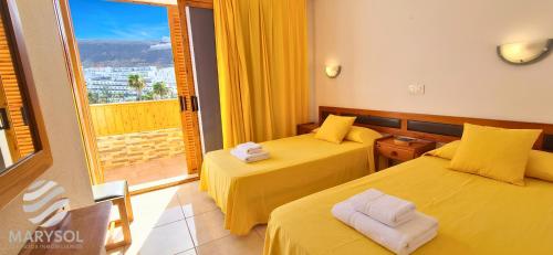 a hotel room with two beds and a balcony at Apartamentos Panamá in Puerto Rico de Gran Canaria