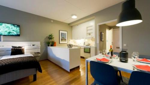 a bedroom with a bed and a table and a kitchen at Apartment in Skarholmen Stockholm 206 in Stockholm
