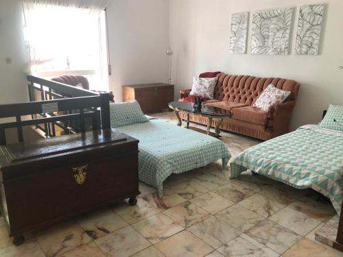 a living room with a couch and two ottomans at Vivenda Alves in Charneca