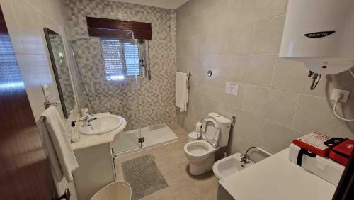 a bathroom with a toilet and a sink at Vivenda Alves in Charneca