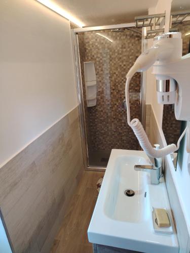 a bathroom with a white sink and a shower at Baita LA CANAL in Monastero di Lanzo