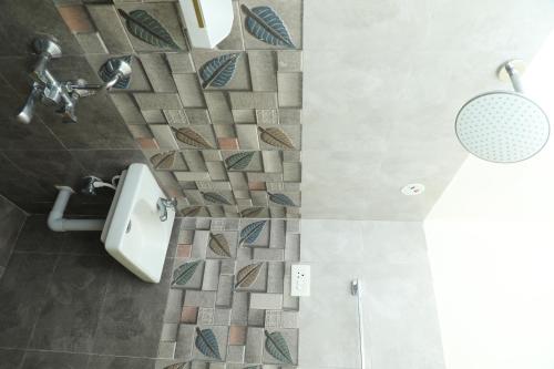 a bathroom with a shower and a toilet in it at NJ Grand Villa in Kālapettai