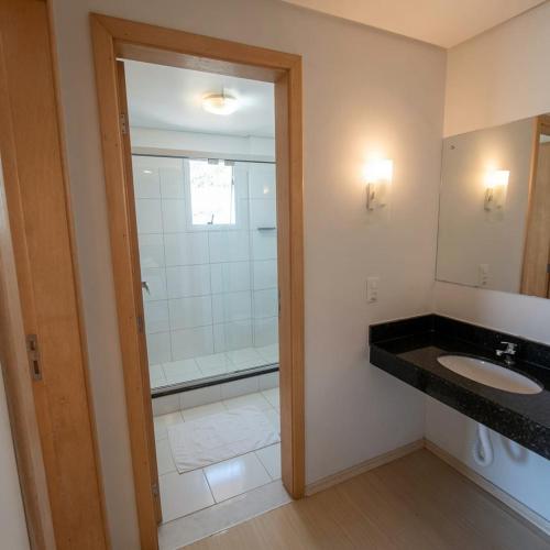 a bathroom with a shower and a sink and a mirror at Hotel Aguadero in Passo Fundo