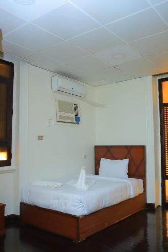 a bedroom with a bed with a air conditioner on the wall at Kings palace castle in Cairo