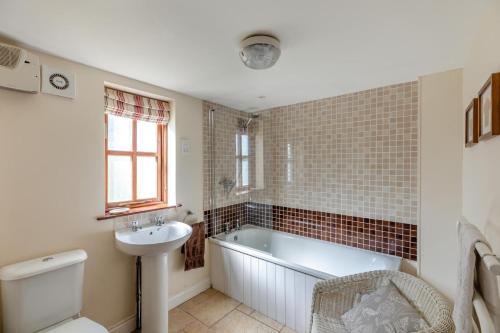 a bathroom with a tub and a sink and a toilet at 2 Bed in Presteigne oc-75066 in Whitton
