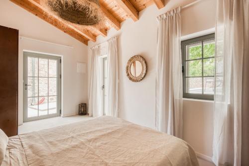 a bedroom with a bed and two windows at Doma in Supetar