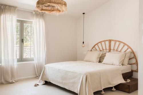 a white bedroom with a large bed and a window at Doma in Supetar