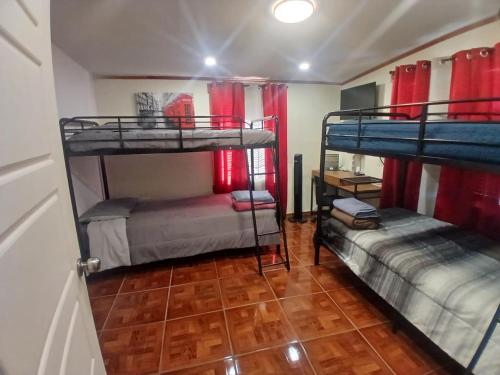 a room with two bunk beds and a wooden floor at Alojamiento Los Andes in Brownsville