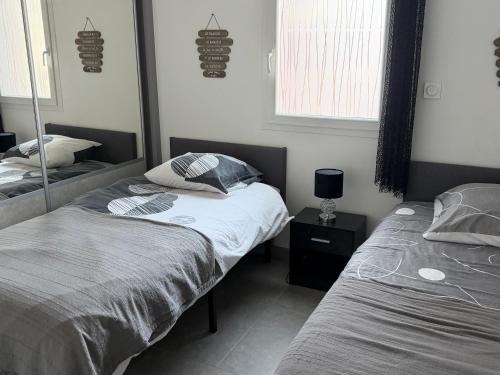 a bedroom with two twin beds and a mirror at Pitchoun in Velaux