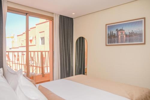 a hotel room with a bed and a window at Residence Eden Marrakech in Marrakesh