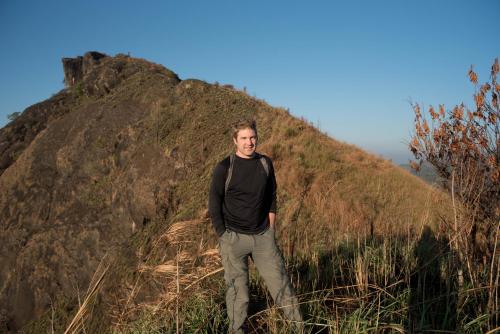 a man standing on the side of a hill at View Valley Homestay in Munnar