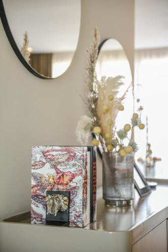 a table with two books and a vase with flowers at Residence Eden Marrakech in Marrakesh